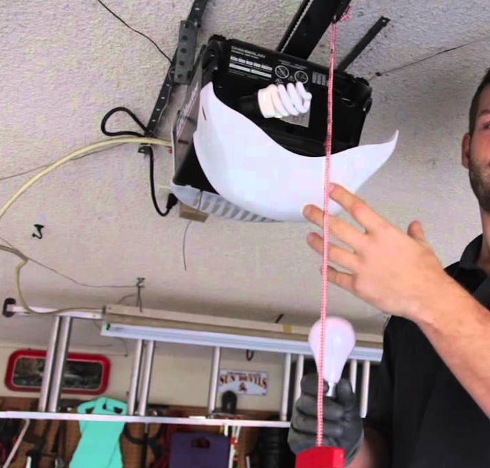 Alt Text: "Technician repairing a garage door opener in Orlando, FL"