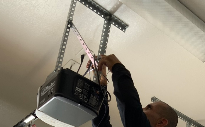 Alt Text: "Experienced technician repairing a garage door opener in Orlando, FL, enhancing functionality and performance for residential customers."