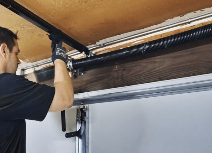 Professional garage door spring repair services in Orlando, FL - Orlando FL Garage Door Repair Services team fixing a spring on a residential garage door.